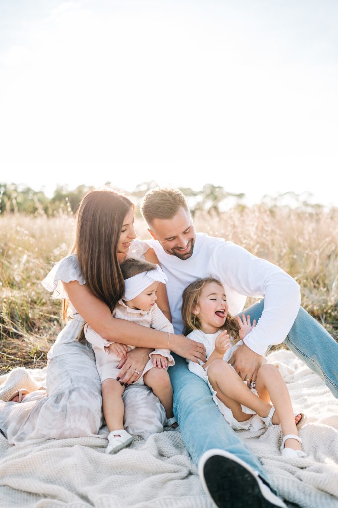 Family laughing during South Florida field family session.