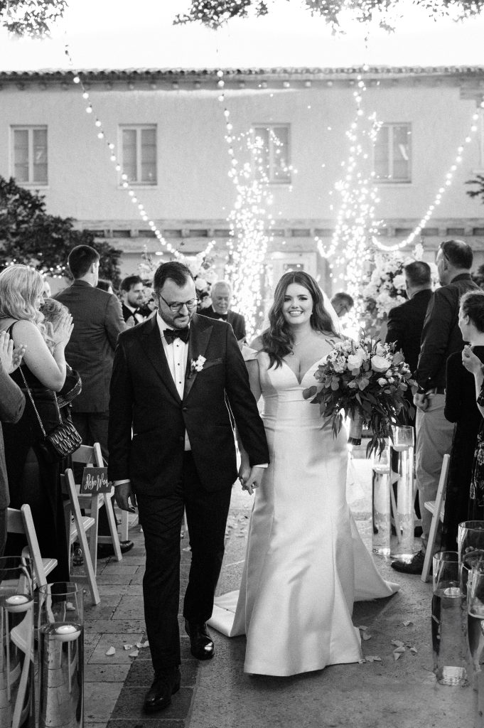 Palm Beach Wedding photographer, Bela Freire, captures couple as they walk down the aisle, with sparks flying in the backgroun.