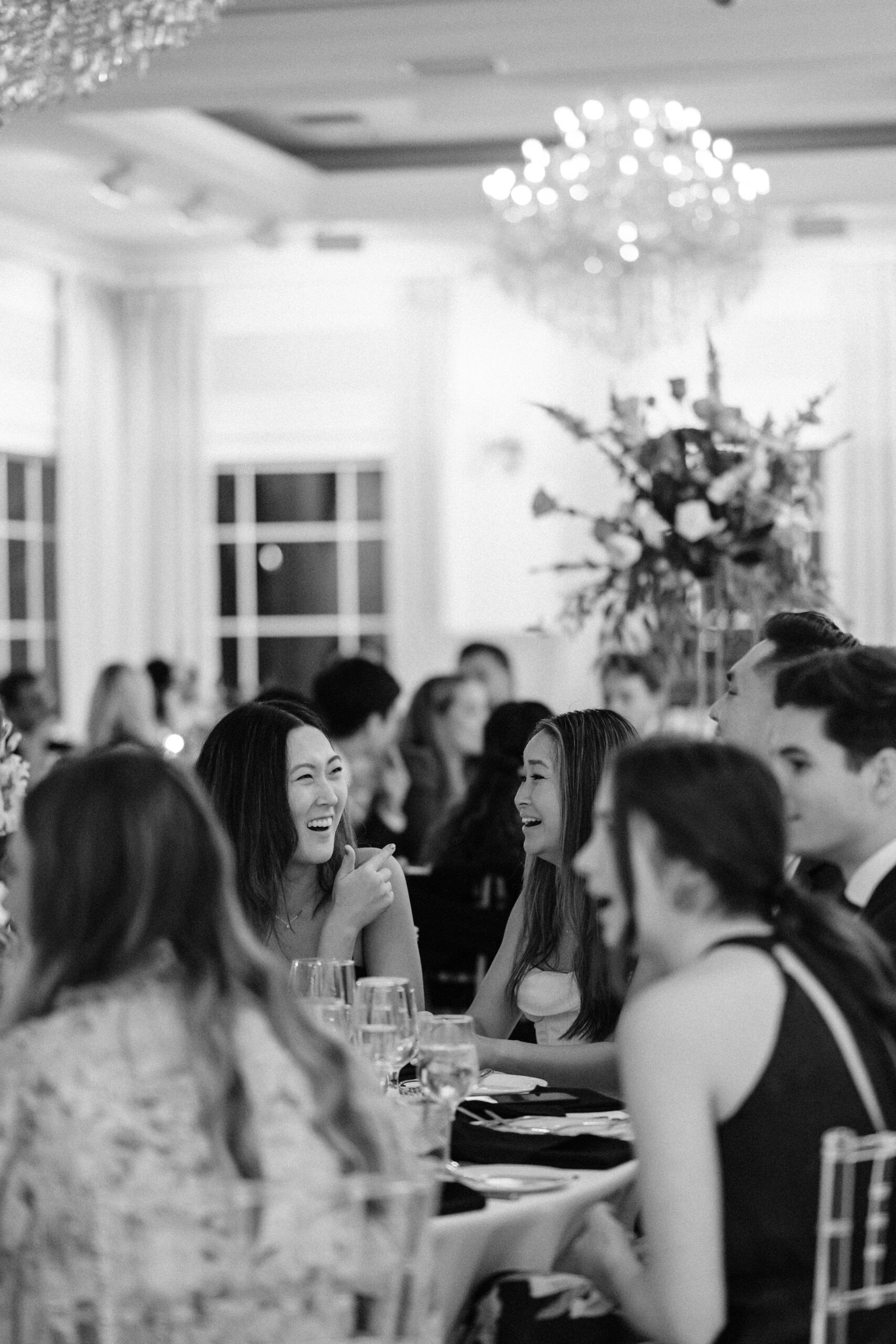 Friends laughing during wedding reception captured by Benvenuto Wedding Photographer