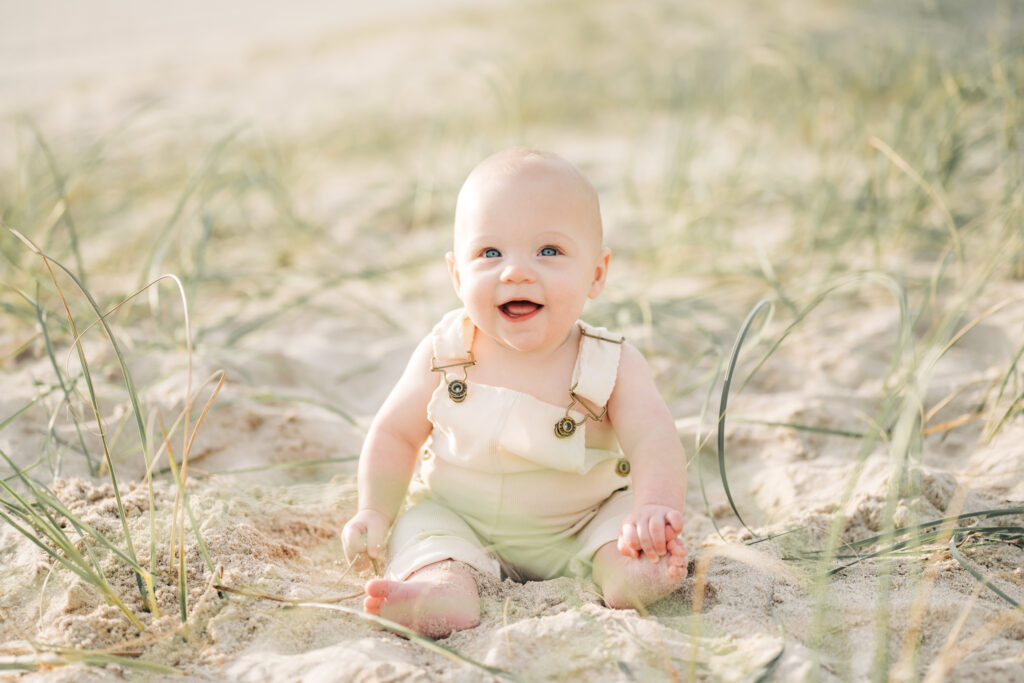 a baby sitting in the sand during Pompano Beach Family Photos 